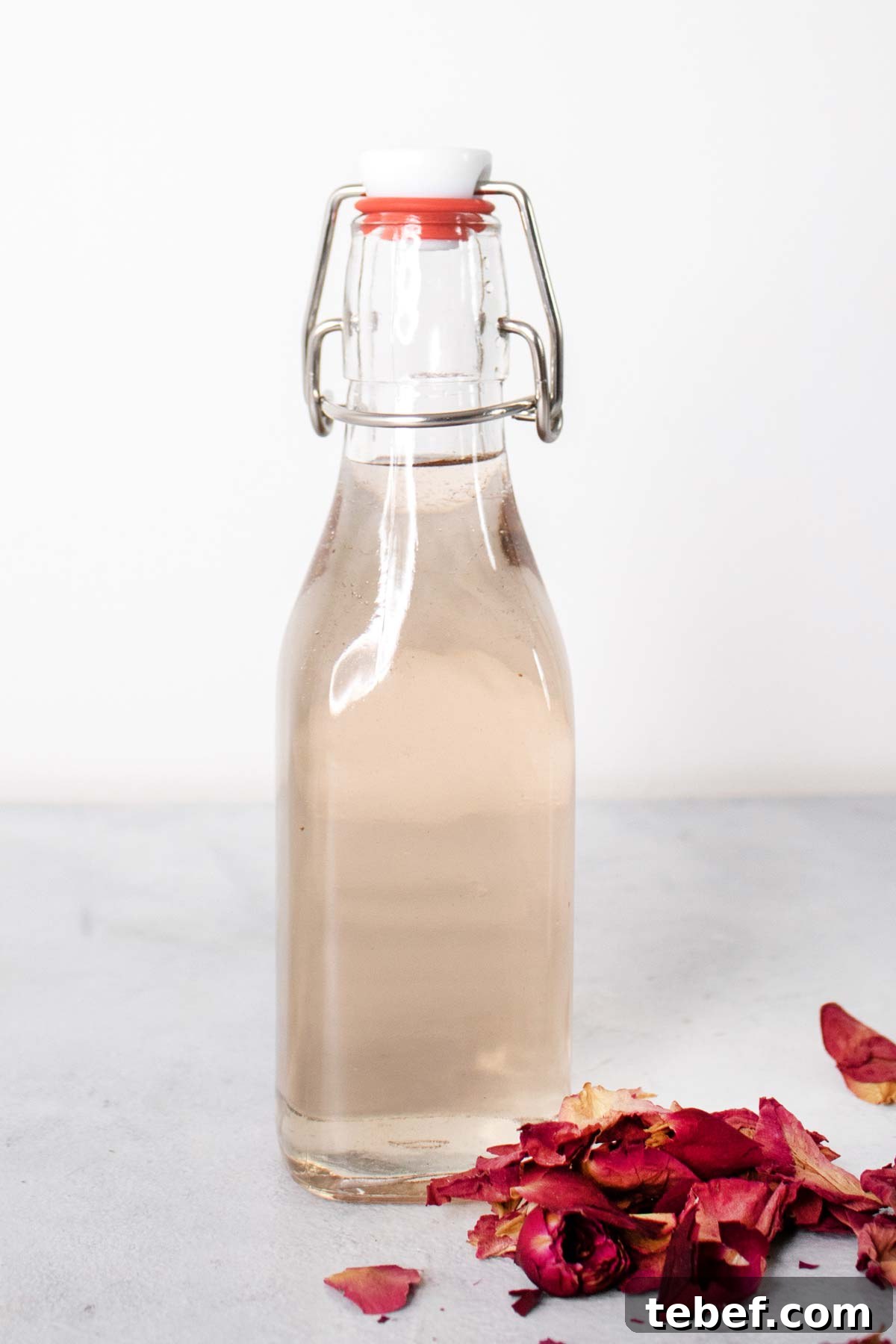 Homemade Rose Syrup Recipe for Fragrant Drinks and Desserts 2 Rose syrup in a glass bottle.