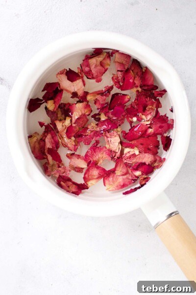 Homemade Rose Syrup Recipe for Fragrant Drinks and Desserts 4 Rose petals in a saucepan with water.