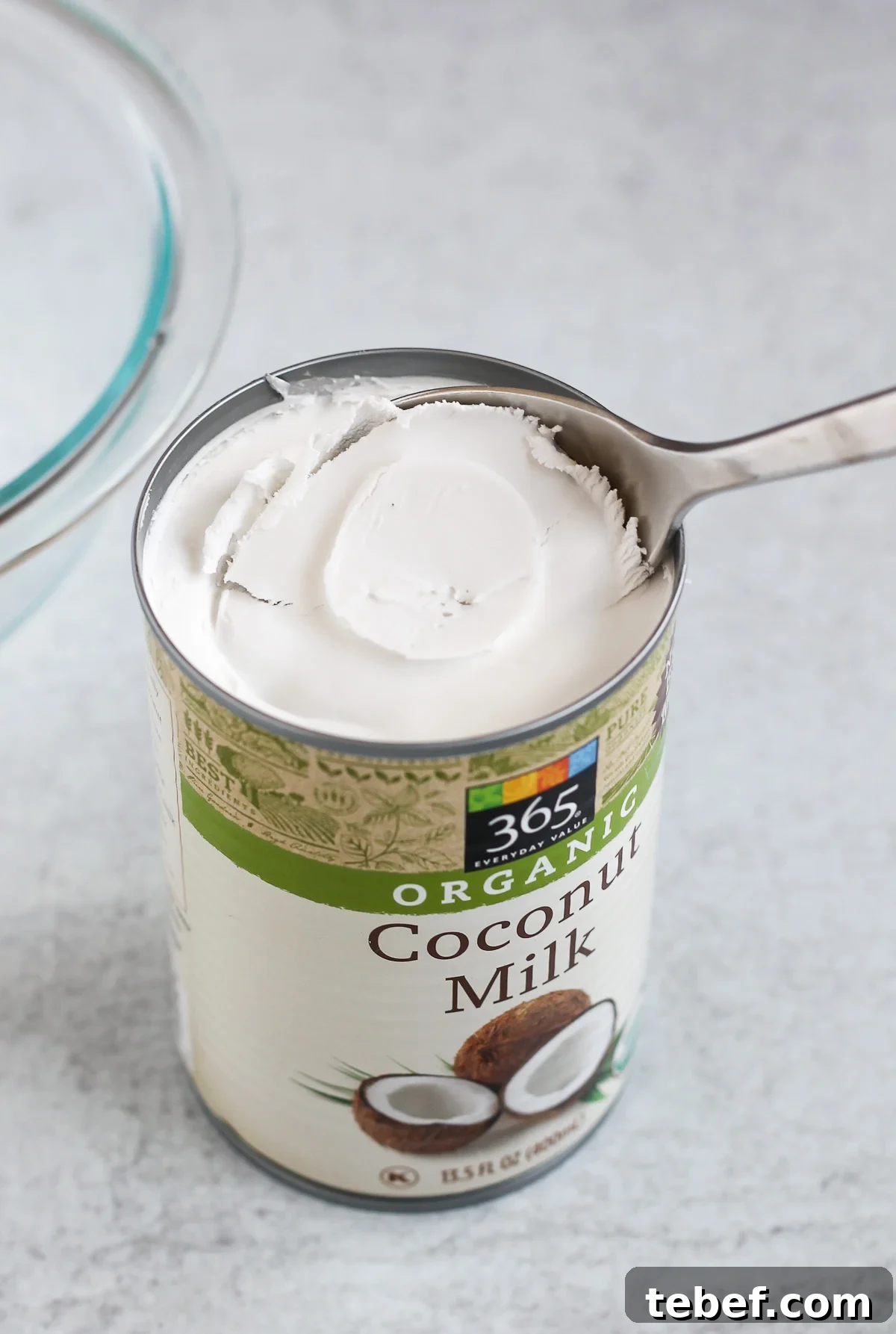 Coconut Whipped Cream Recipe: Light, Dairy-Free Topping in Minutes 3 close up coconut milk can with the coconut cream being scooped out