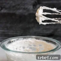 Coconut Whipped Cream Recipe: Light, Dairy-Free Topping in Minutes 7 electric beater with whipped coconut cream standing over mixing bowl