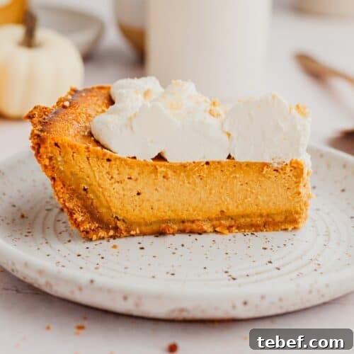 A slice of pumpkin pie topped with whipped cream.