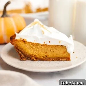 A slice of pumpkin pie with marshmallow topping on a small plate.