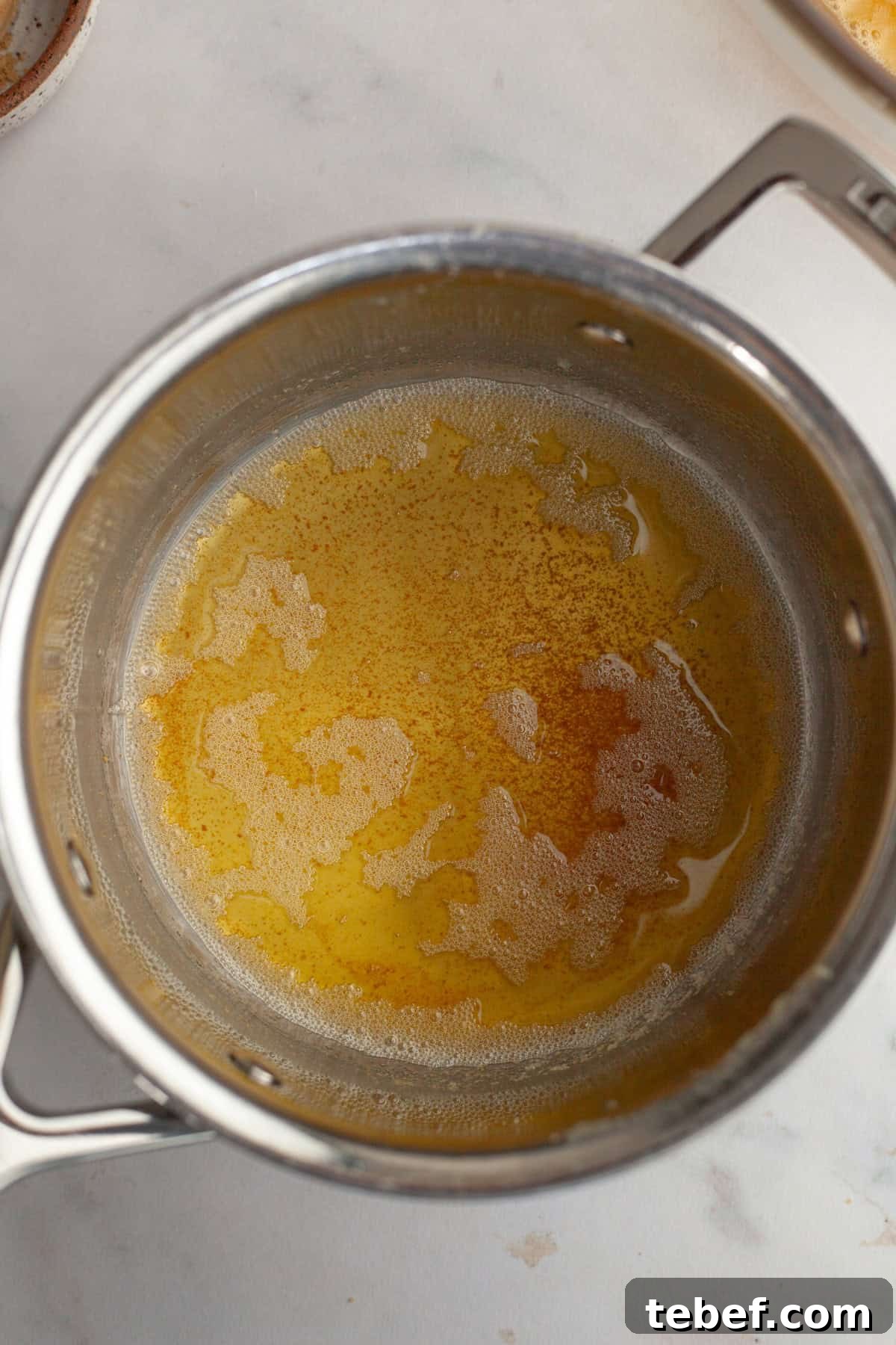 A small saucepan with brown butter in it.