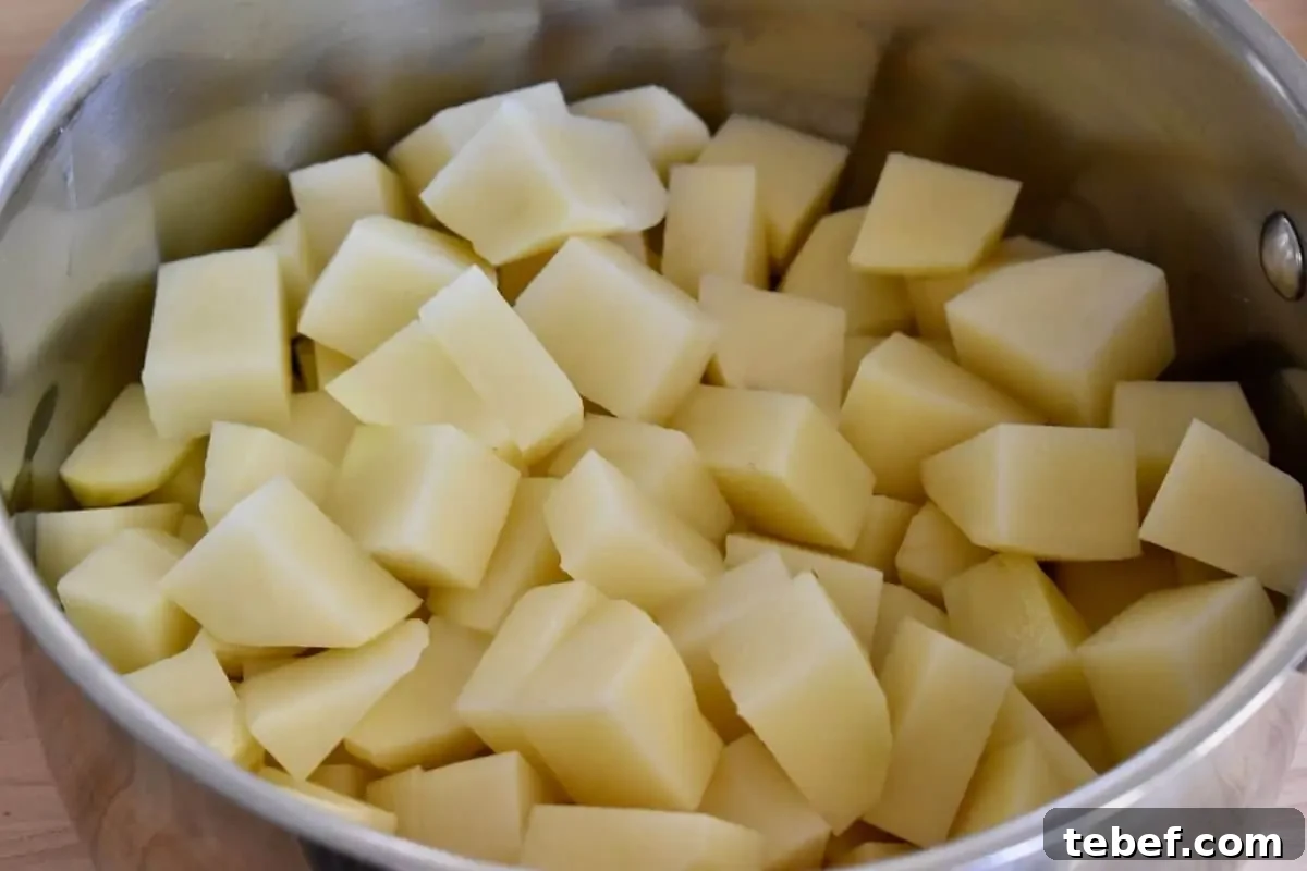 Cheesy Ham and Potato Casserole Recipe for Leftover Ham 5 Peeled and cubed and potatoes in a pot.