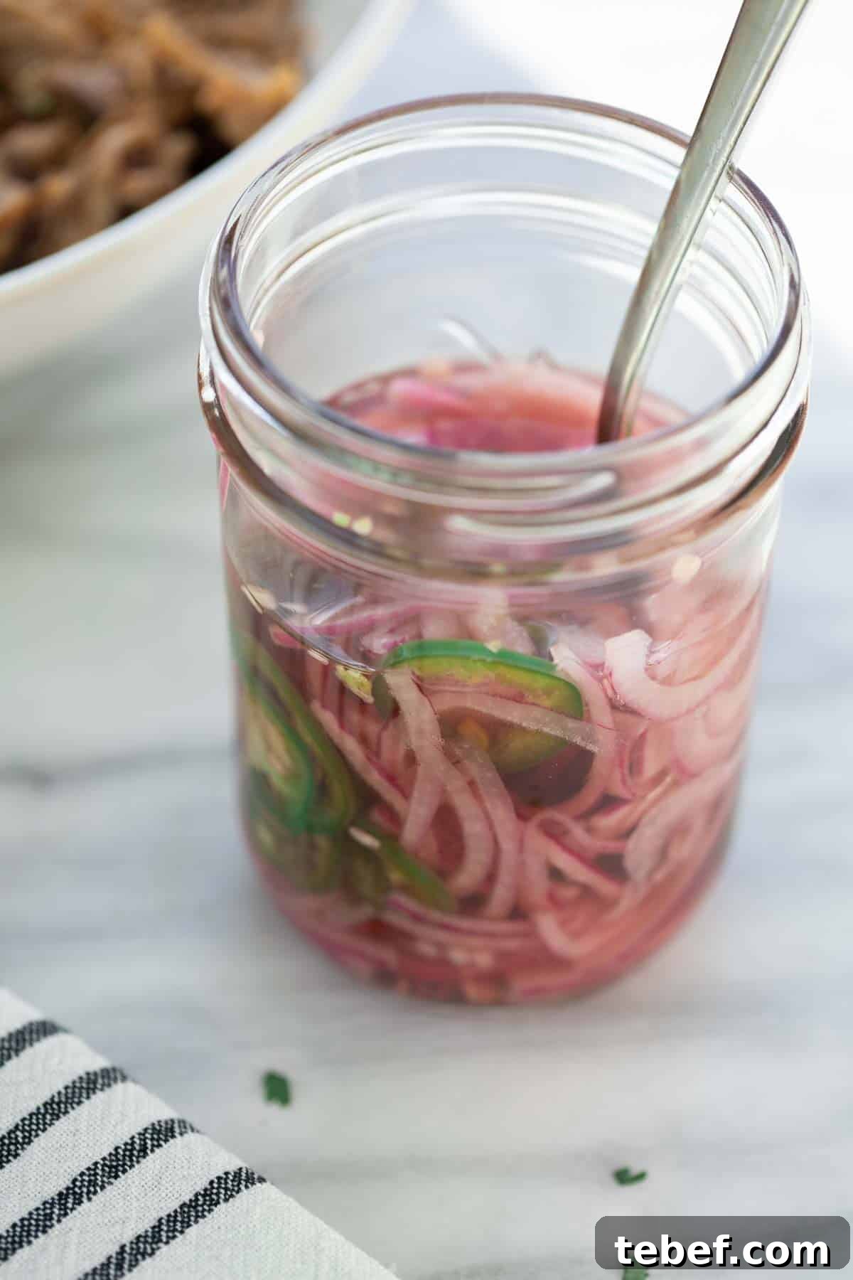 Slow-Cooker Sweet Pork Tacos Recipe for Tender, Flavorful Tacos 7 pickled onions in mason jar with fork on marble background