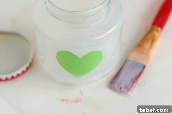 Mess-Free Glitter Tea Light Lanterns for Sparkling Home Decor 5 glass jar brushed with glue and contact paper heart stuck inside