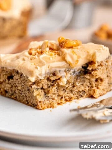 A slice of banana snack cake on a plate with a fork.