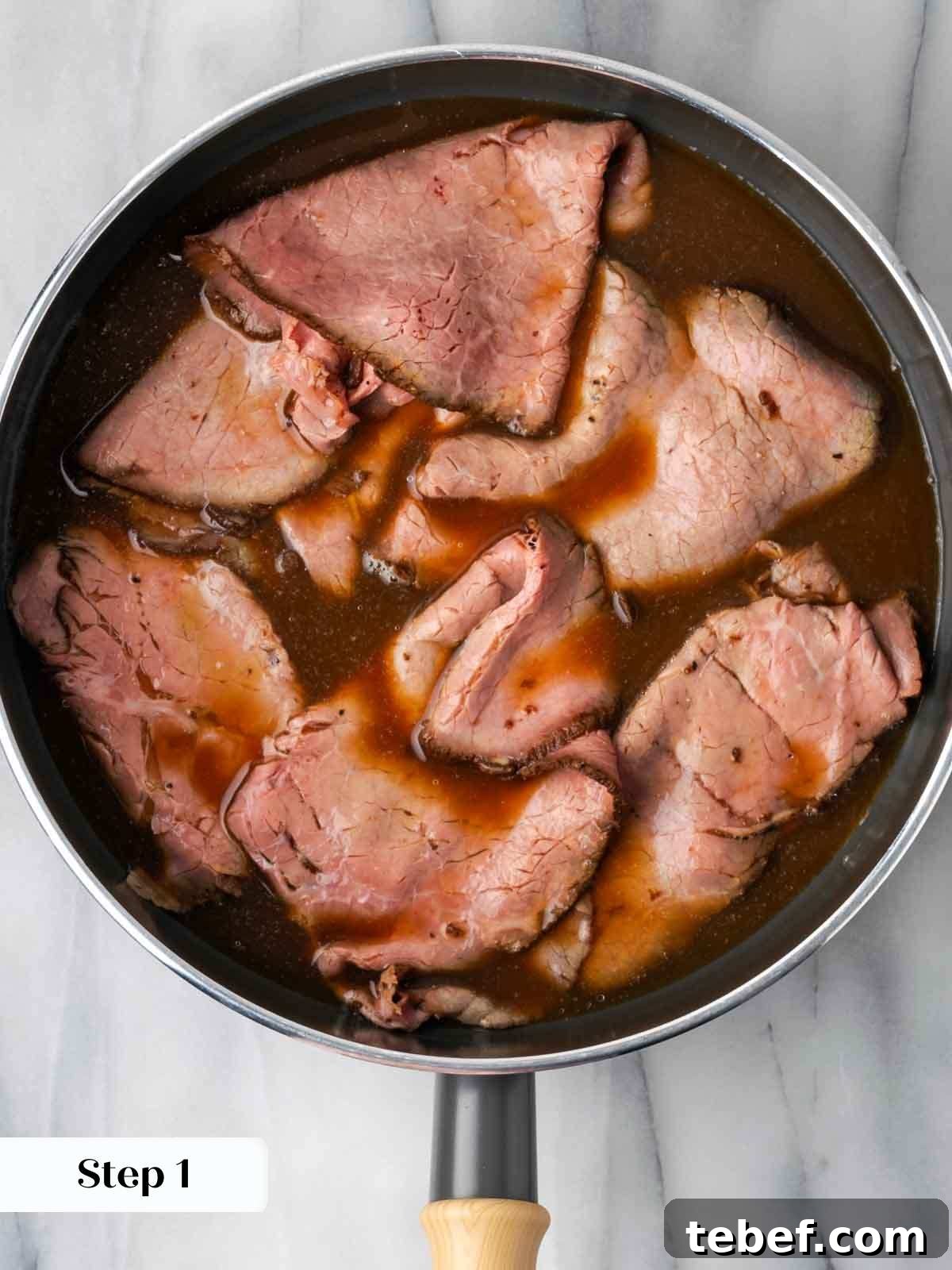 roast beef in pan with jus.