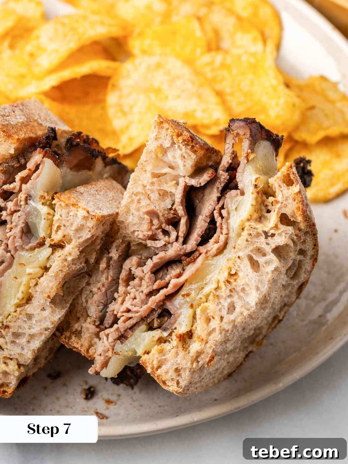 finished sliced sandwich on plate with chips.