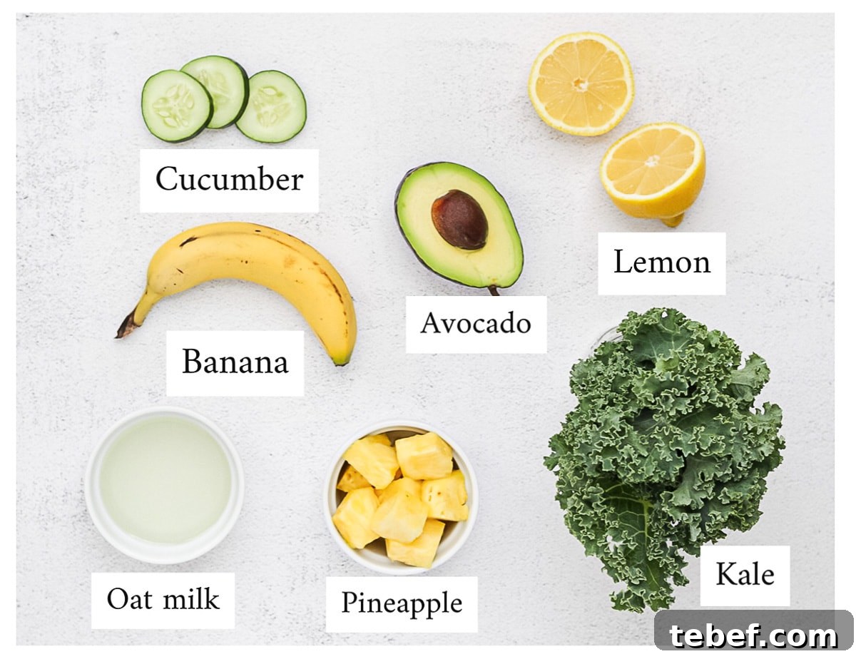 All ingredients are laid out and labeled, including: kale, pineapple, oat milk, lemon, avocado, banana, and cucumber.