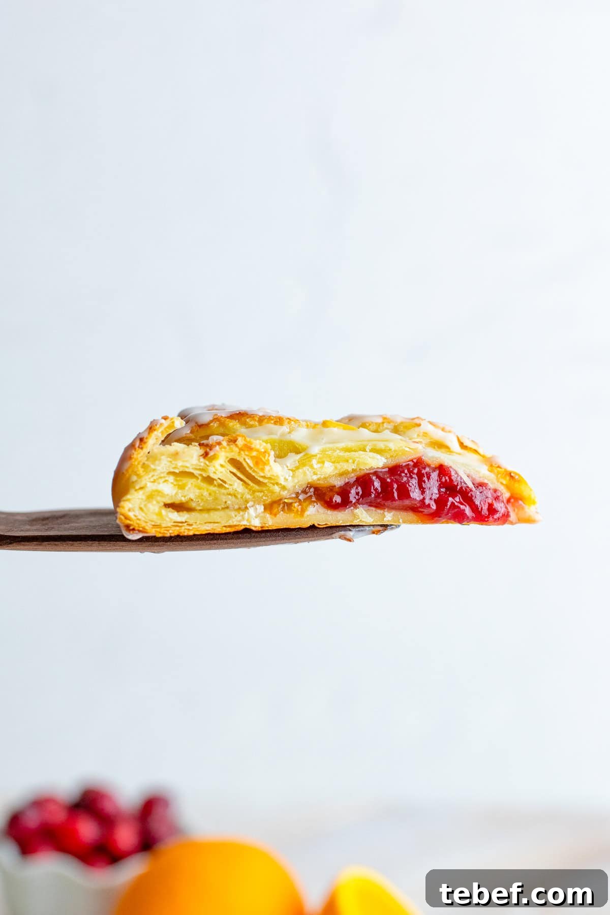 Cranberry Orange Sweet Braid Recipe — Flaky Holiday Pastry 6 Spatula holding up slices of braid