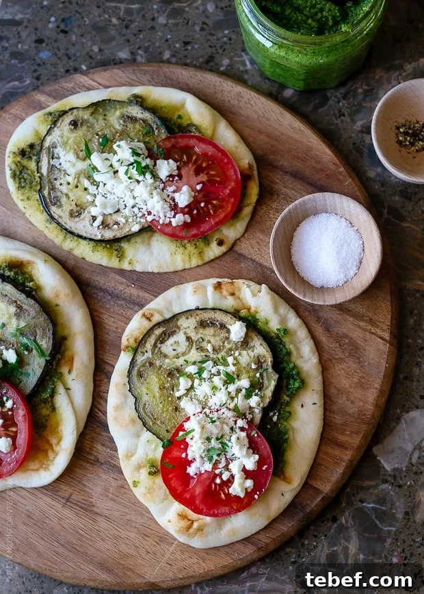 Roasted Eggplant, Tomato and Pesto Mini Naan on a wooden serving board.