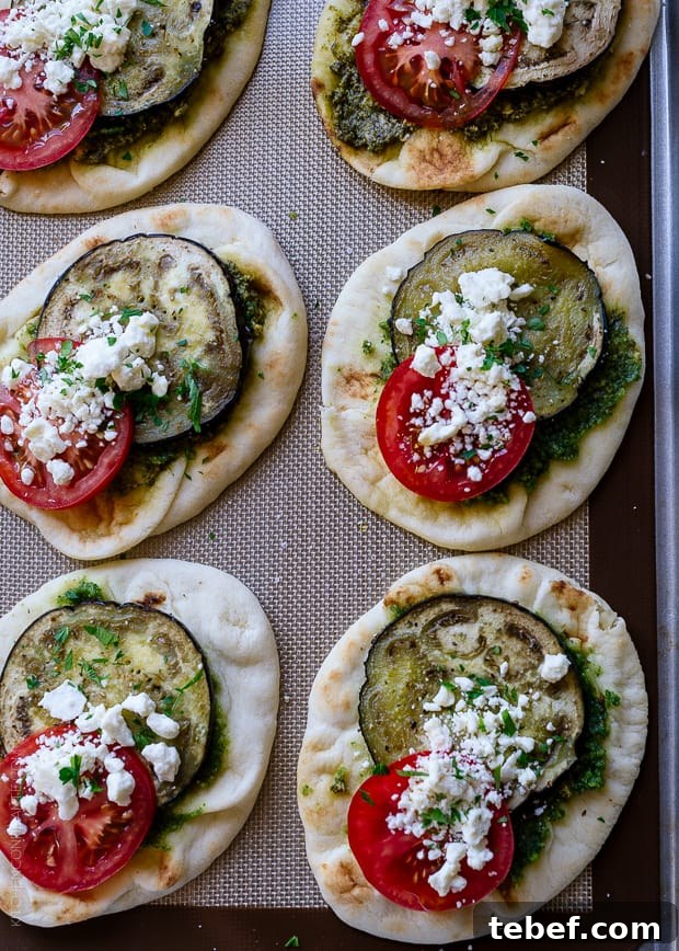 Roasted Eggplant, Tomato and Pesto Mini Naan on a baking sheet.