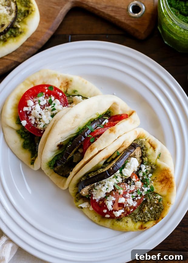Roasted Eggplant, Tomato & Pesto Mini Naan on a white plate.