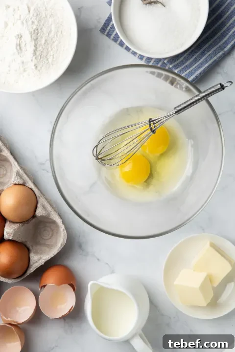 cracked eggs in a bowl with a whisk