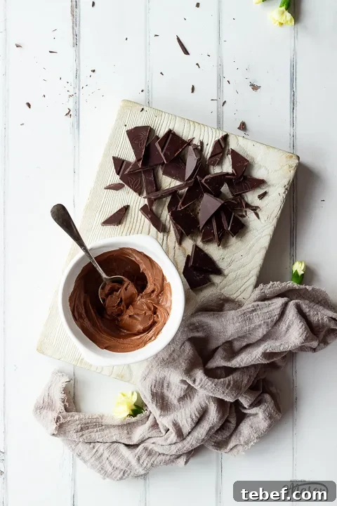 Broken chocolate and icing on a wooden board