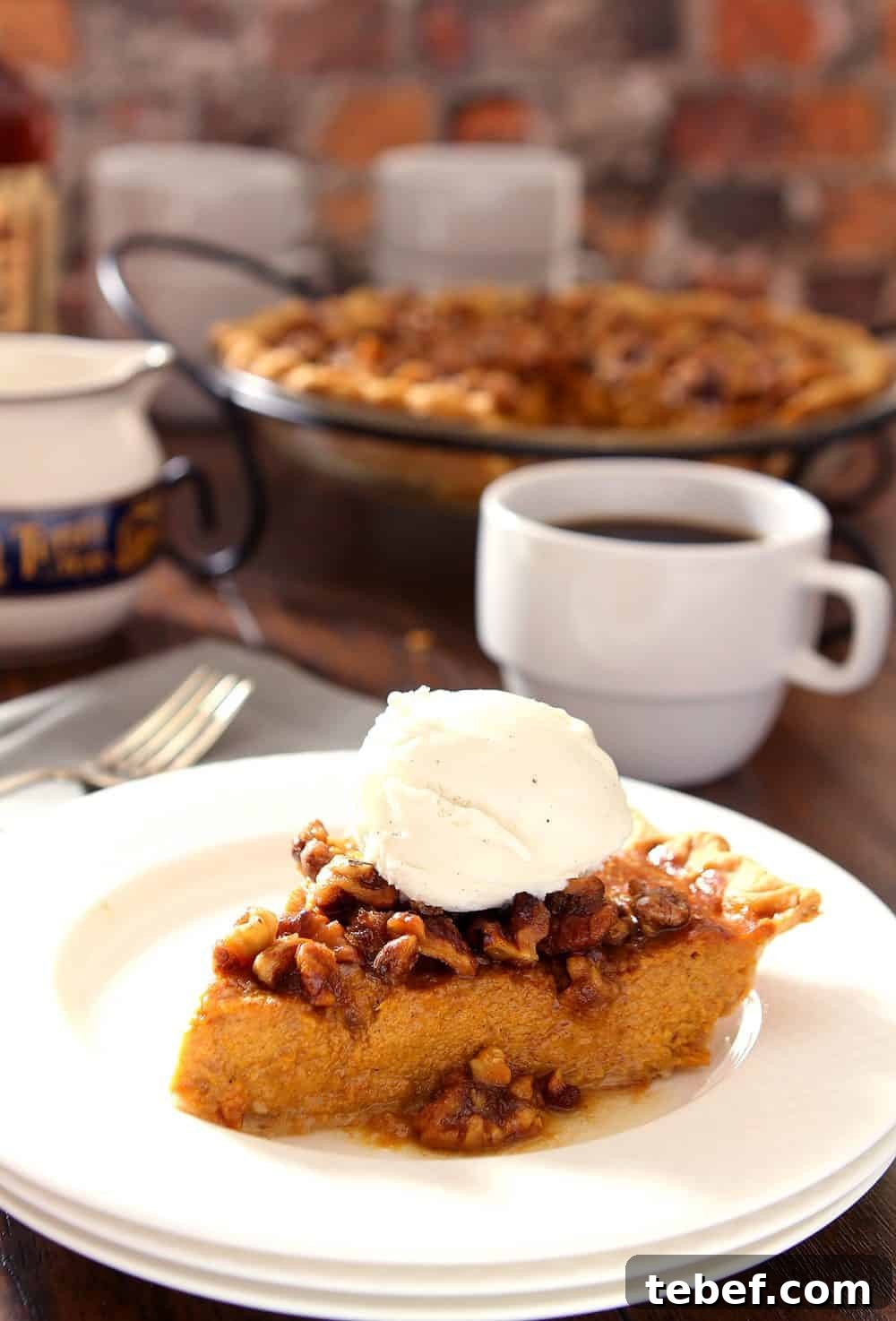 Bourbon Pumpkin Pie with Toasted Walnut Crumble 3 Slice of Bourbon and Pumpkin Pie on a white plate and topped with whipped cream.