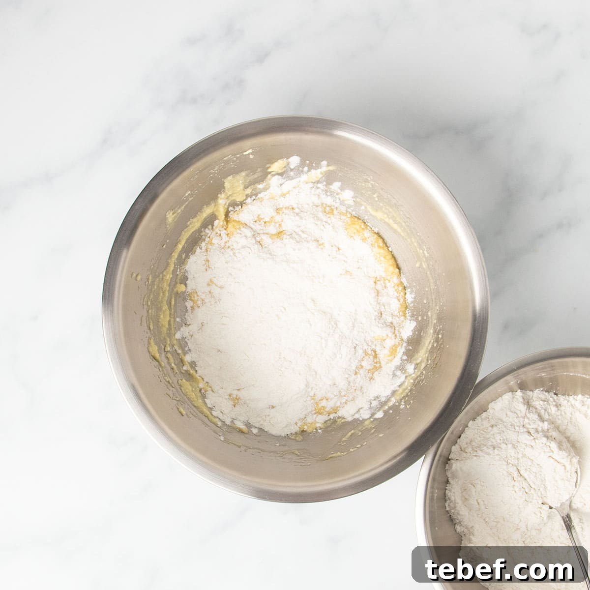 Gluten-Free Vanilla Cupcakes Recipe for Moist, Fluffy Results 9 white powder dry ingredients unmixed on top of yellow butter and egg mixture