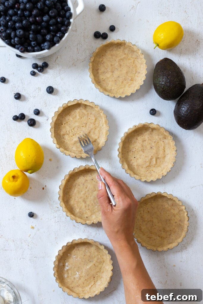Pricking the almond shortbread tart shells with fork