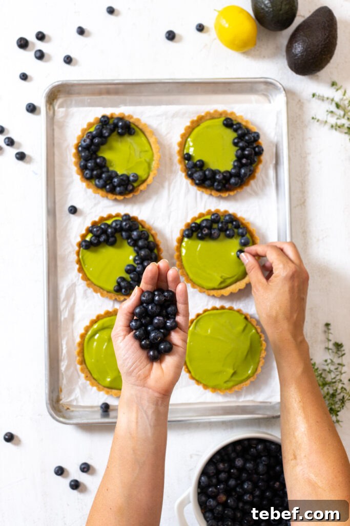 Topping Avocado Blueberry Tarts with Almond Crust with fresh blueberries
