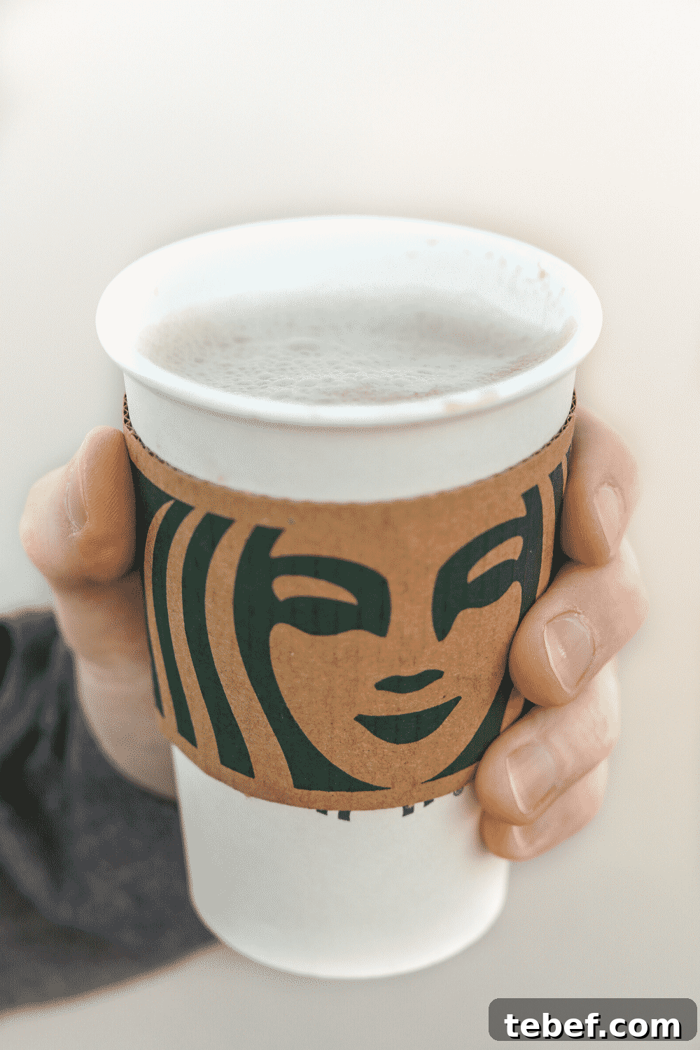 A hand holding a cup of Starbucks caffe Misto