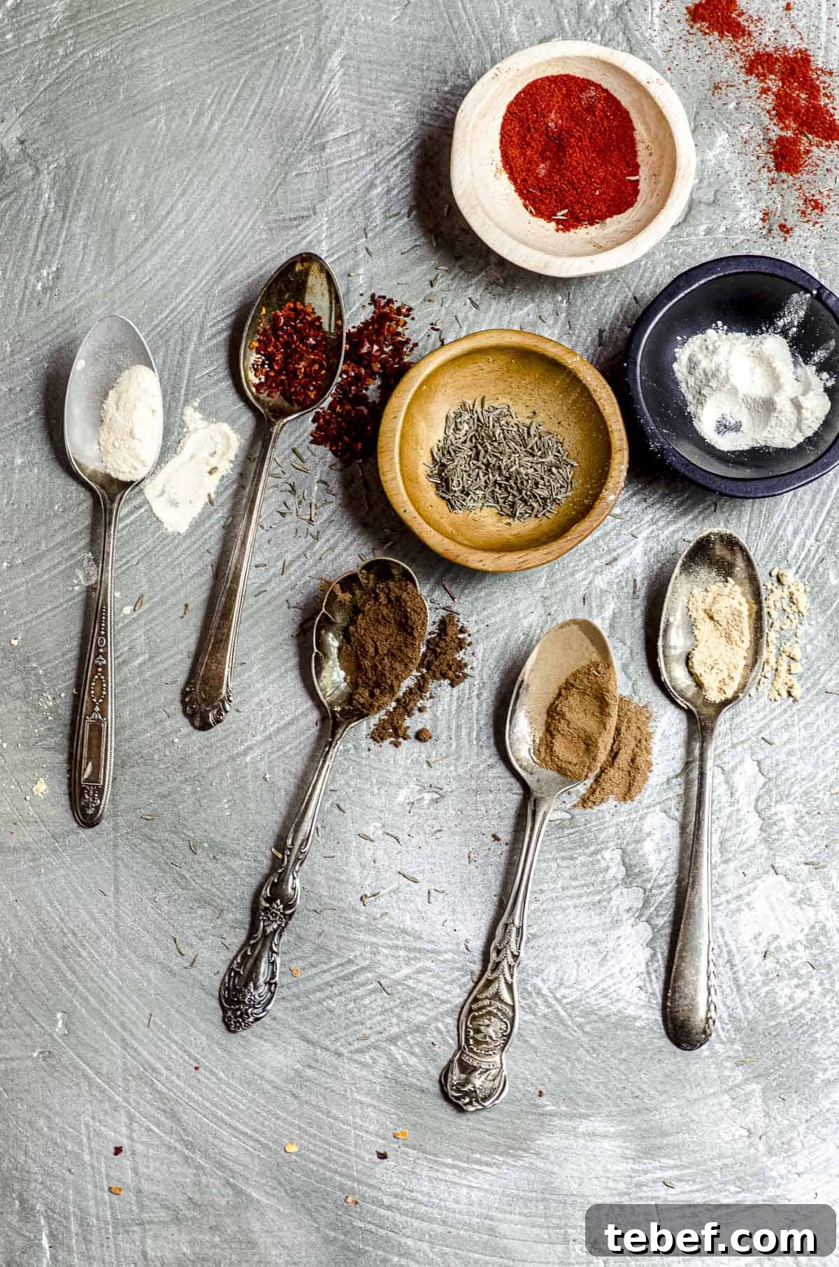 Authentic Jamaican Jerk Seasoning Recipe & Homemade Spice Blend 5 3 small bowls with different spices and five small spoons with spices to make Jamaican jerk
