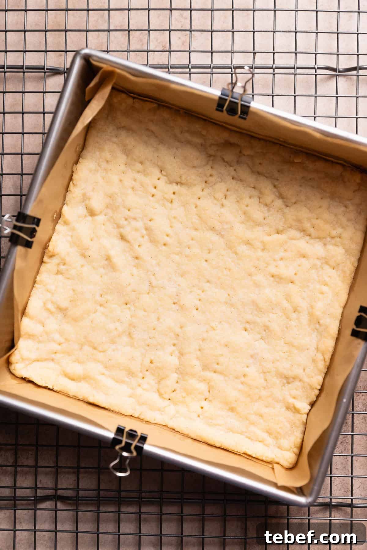 Zesty Lemon Bars with Buttery Shortbread Crust 5 A pan with the baked shortbread crust cooling on a wire rack.
