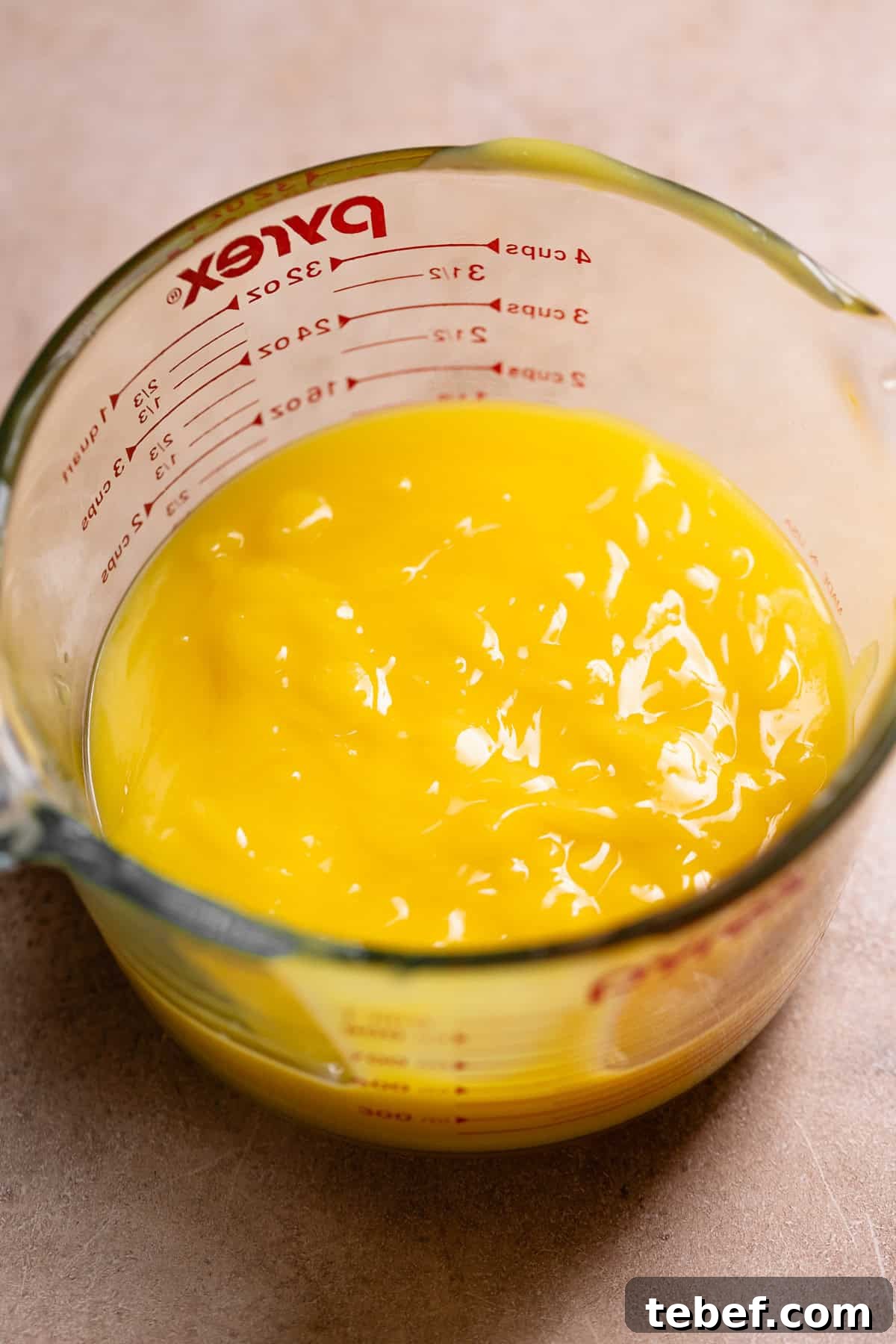 Zesty Lemon Bars with Buttery Shortbread Crust 6 Lemon curd in a glass measuring cup.