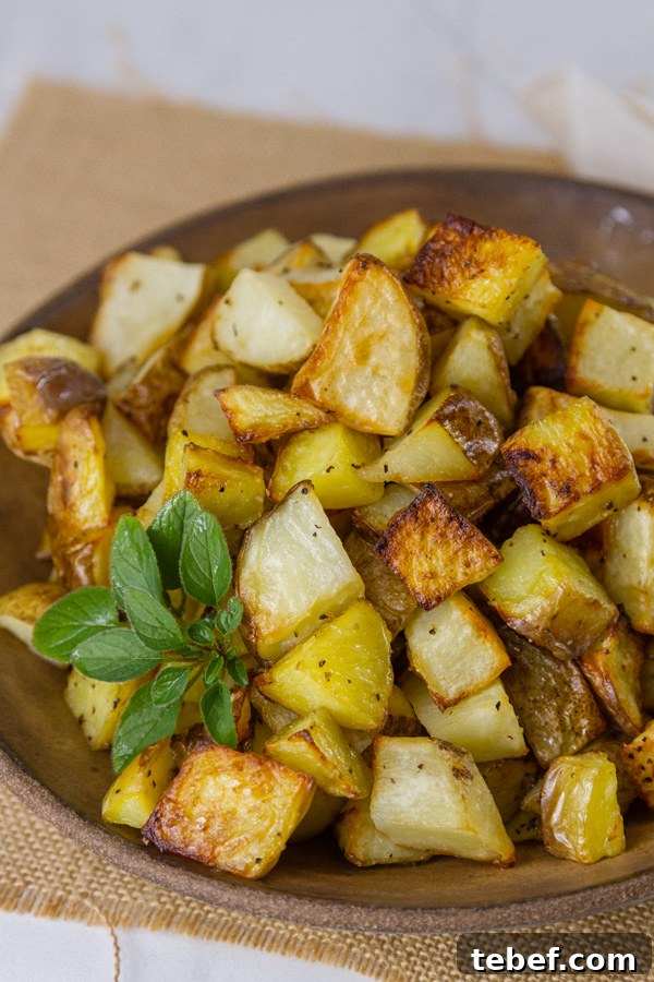 Sheet Pan Roasted Potatoes are an easy, delicious side dish for any meal. This super easy method produces perfectly cooked potatoes that are crispy outside and tender and creamy inside. Sheet Pan Roasted Potatoes in a brown bowl for servings