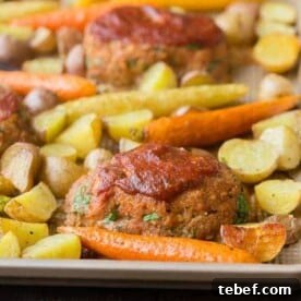 Mini meatloaves and roasted vegetables on sheet pan.