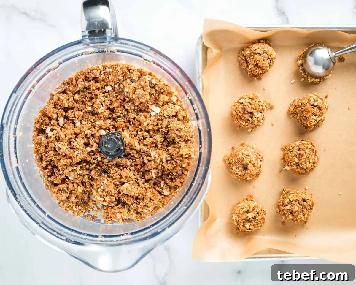 Chocolate-Dipped Matzo Crack Balls: Crispy Sweet Snack Recipe 8 Scooping out matzo crack into balls from the bowl of a food processor.