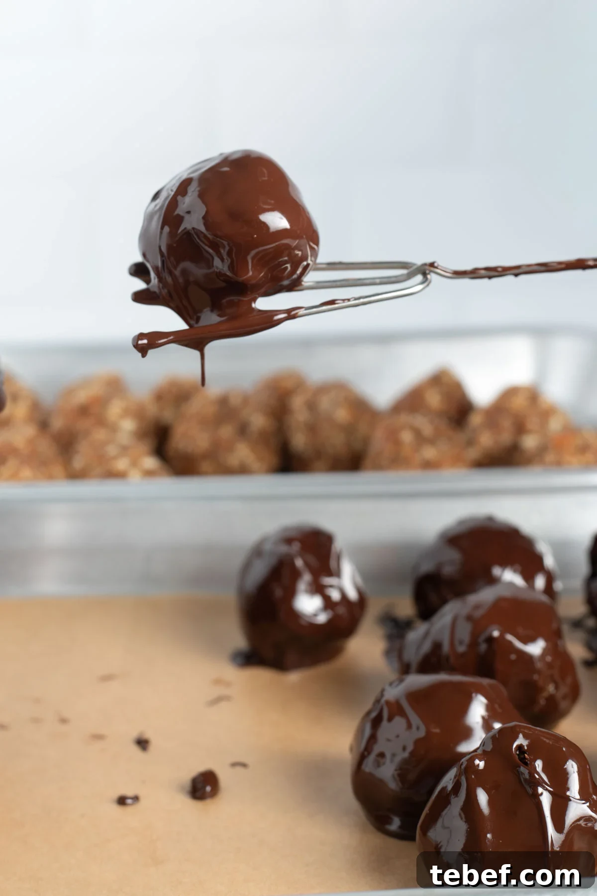 Chocolate-Dipped Matzo Crack Balls: Crispy Sweet Snack Recipe 10 Pulling a chocolate dipped matzo crack ball out of the melted chocolate.