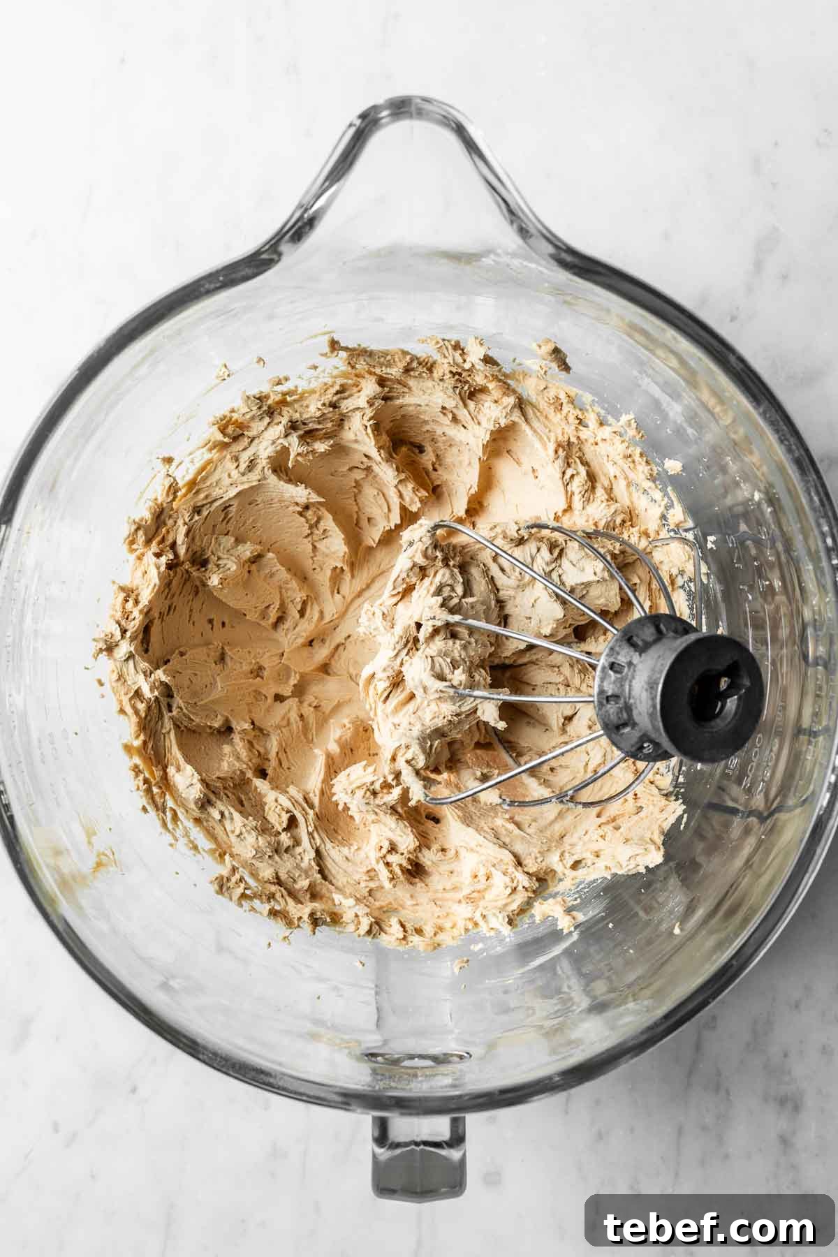 Whipped coffee buttercream frosting in a glass mixing bowl.