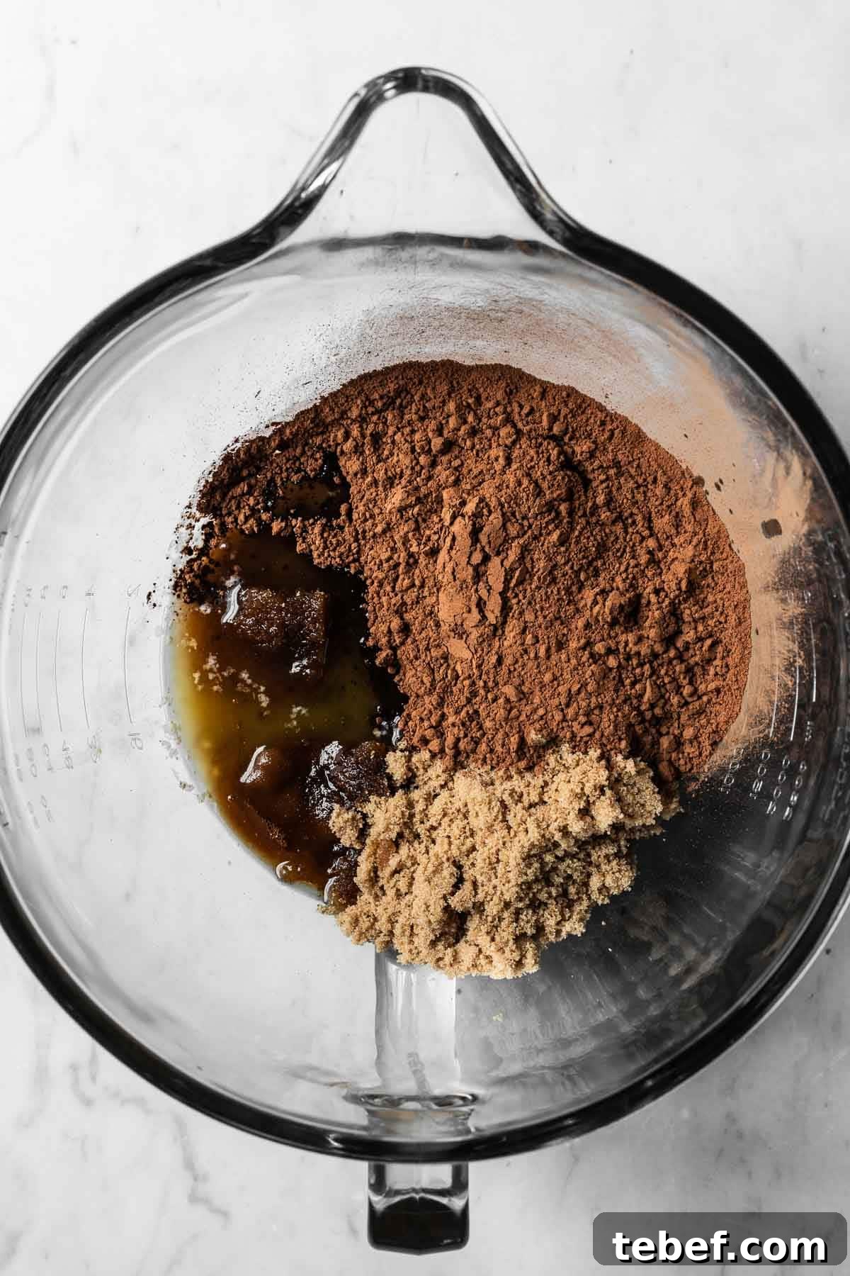 Melted butter, brown sugar and cocoa powder in a glass mixing bowl.