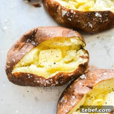 Ultra-Creamy Mashed Potatoes Recipe for Perfect Texture 10 4 split open baked potatoes with butter, salt, and pepper in each of them
