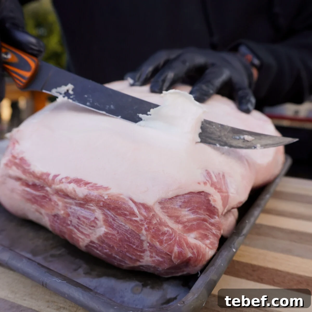 Perfect Slow-Cooker Pulled Pork Sandwich Recipe 4 Trimming fat off a pork shoulder.