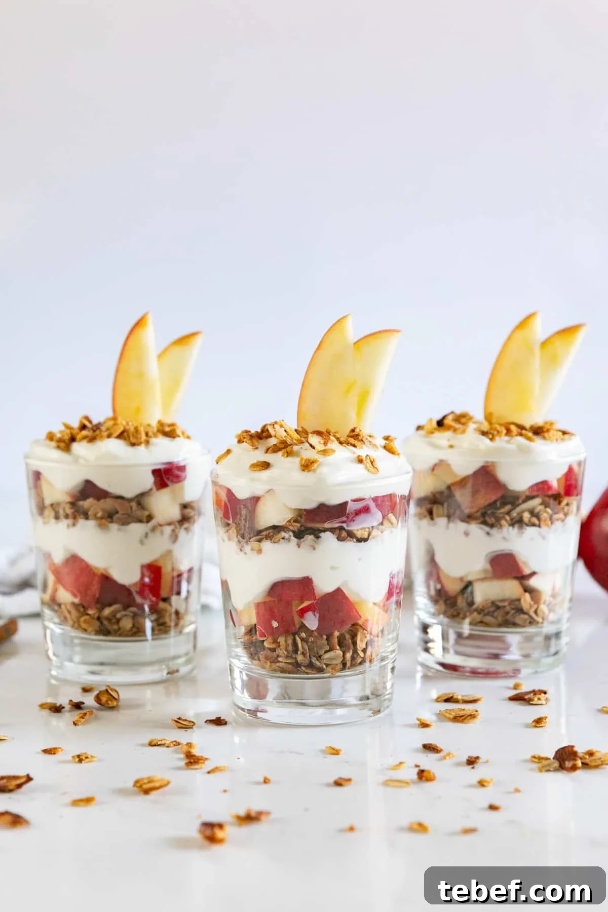 Apple Yogurt Parfait with Cinnamon Granola Recipe 4 3 apple yogurt parfaits with granola around them.