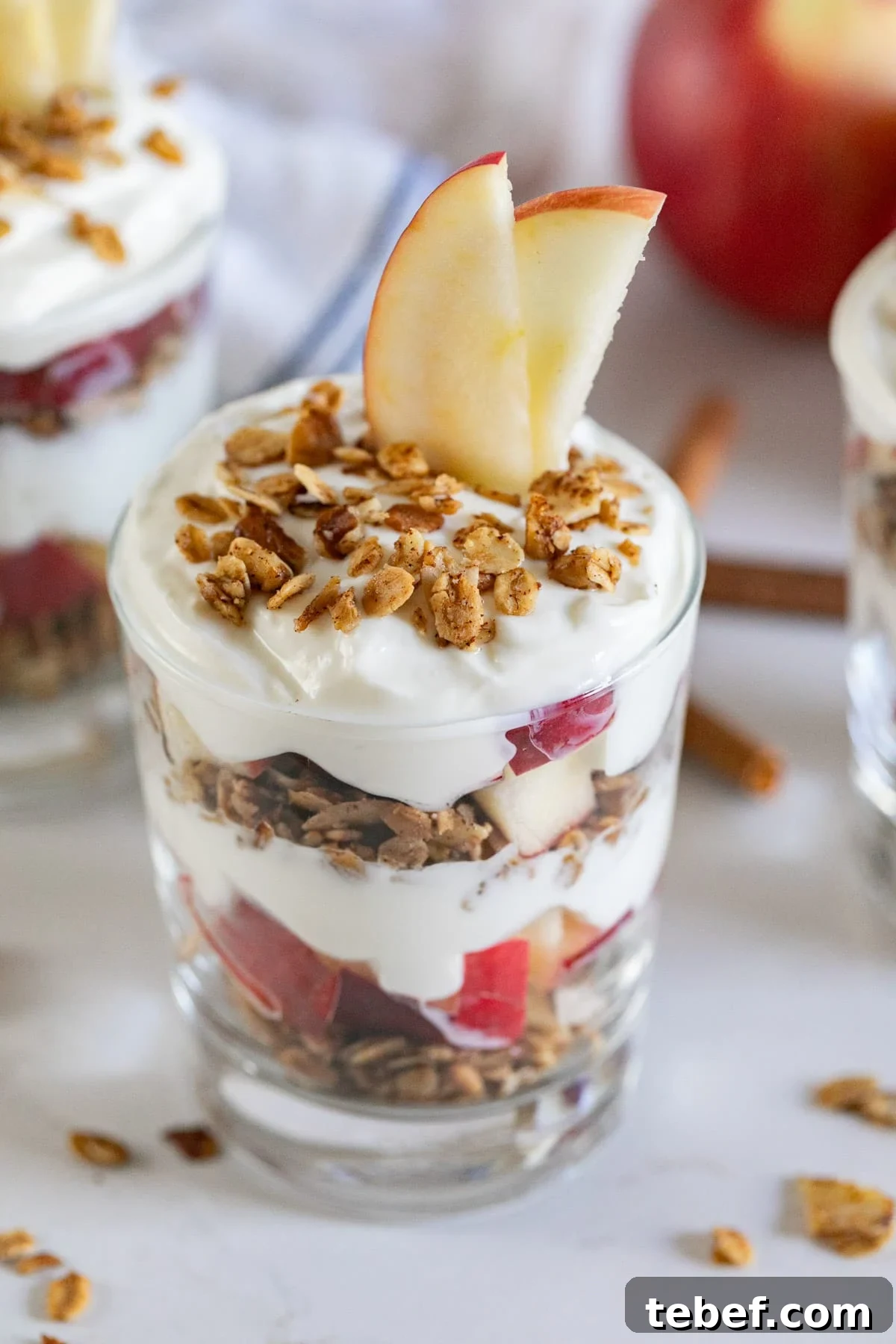 Apple Yogurt Parfait with Cinnamon Granola Recipe 5 A yogurt parfait with apples and granola on top.