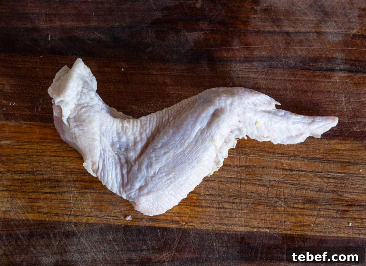 How to Cut Whole Chicken Wings Into Flats and Drumettes for Perfect Portions 3 The front side of a whole chicken wing, not yet separated into the drum, flat, and winglet.