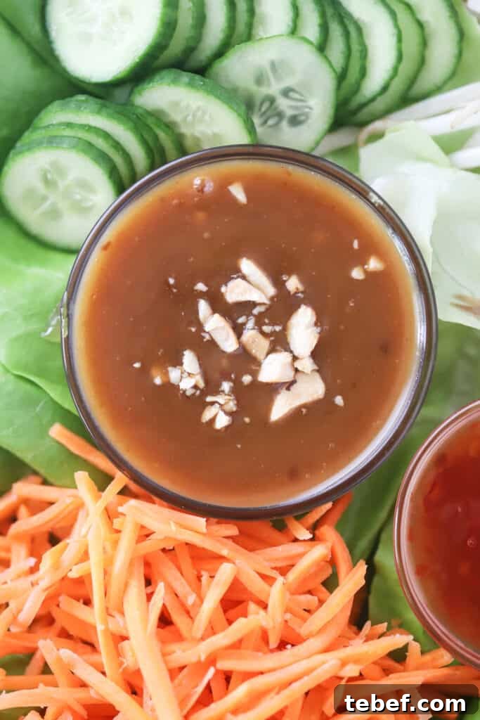 Creamy Thai Peanut Sauce Recipe for Dipping & Stir-Fries 2 A bed of lettuce with julienned carrots, sliced cucumbers, and a ramekin full of pad thai peanut sauce.