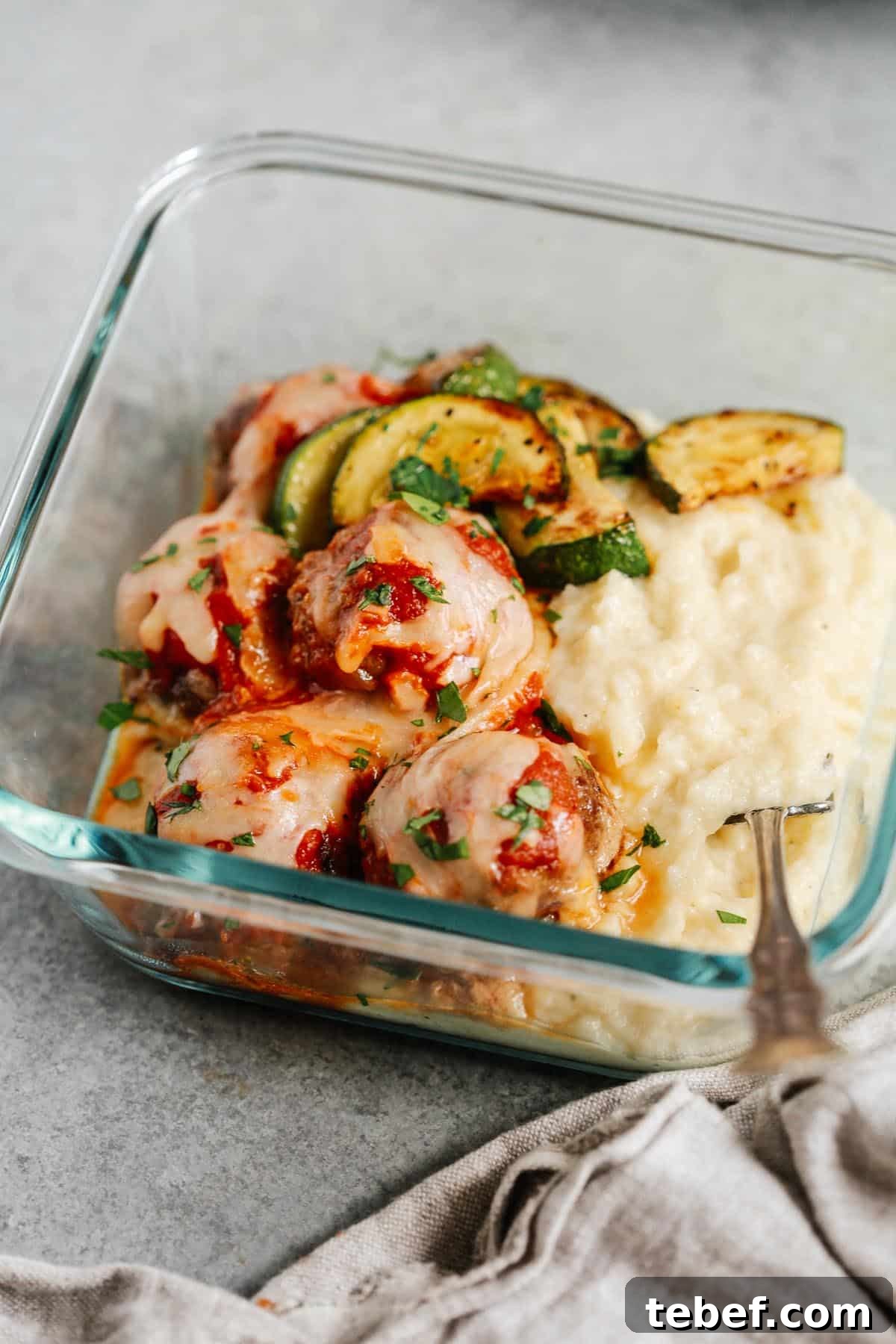 close up of the meatball casserole in a meal prep container 