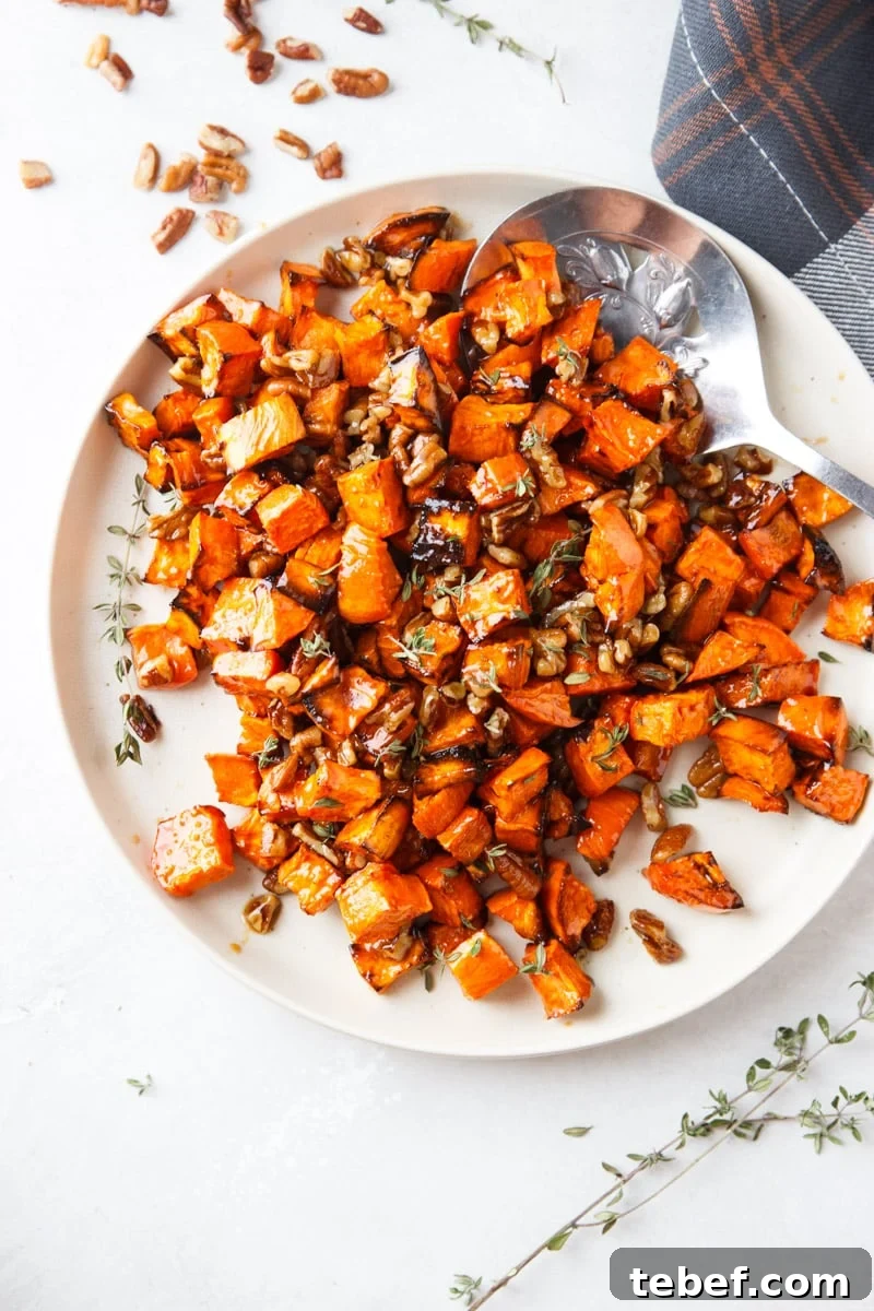 Maple Pecan Sweet Potatoes in the Air Fryer: Crispy & Caramelized 2 Maple sweet potatoes, pecans, silver spoon, white plate, fresh thyme, and plaid cloth.