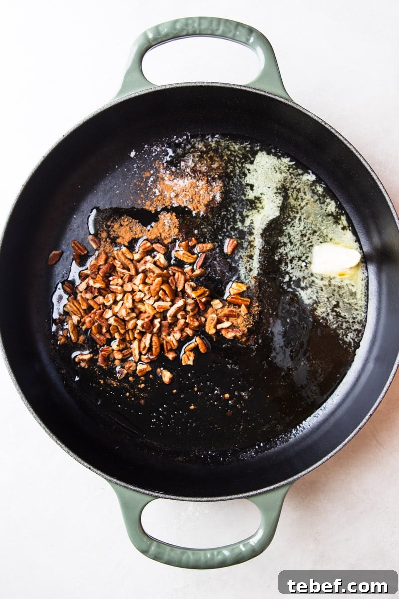 Maple Pecan Sweet Potatoes in the Air Fryer: Crispy & Caramelized 6 Pecans in a skillet with butter and maple syrup.