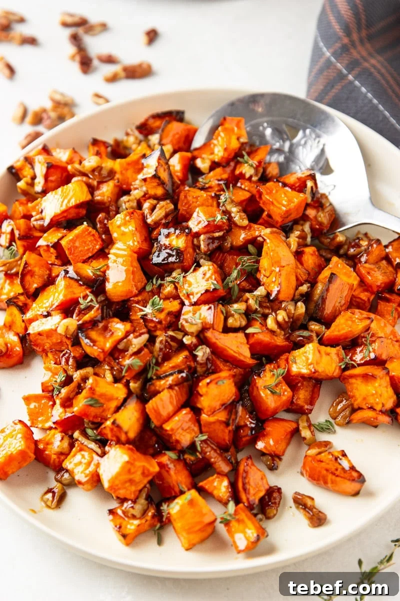 Maple Pecan Sweet Potatoes in the Air Fryer: Crispy & Caramelized 9 Cooked maple sweet potatoes with pecans and fresh thyme, silver spoon, plaid cloth.