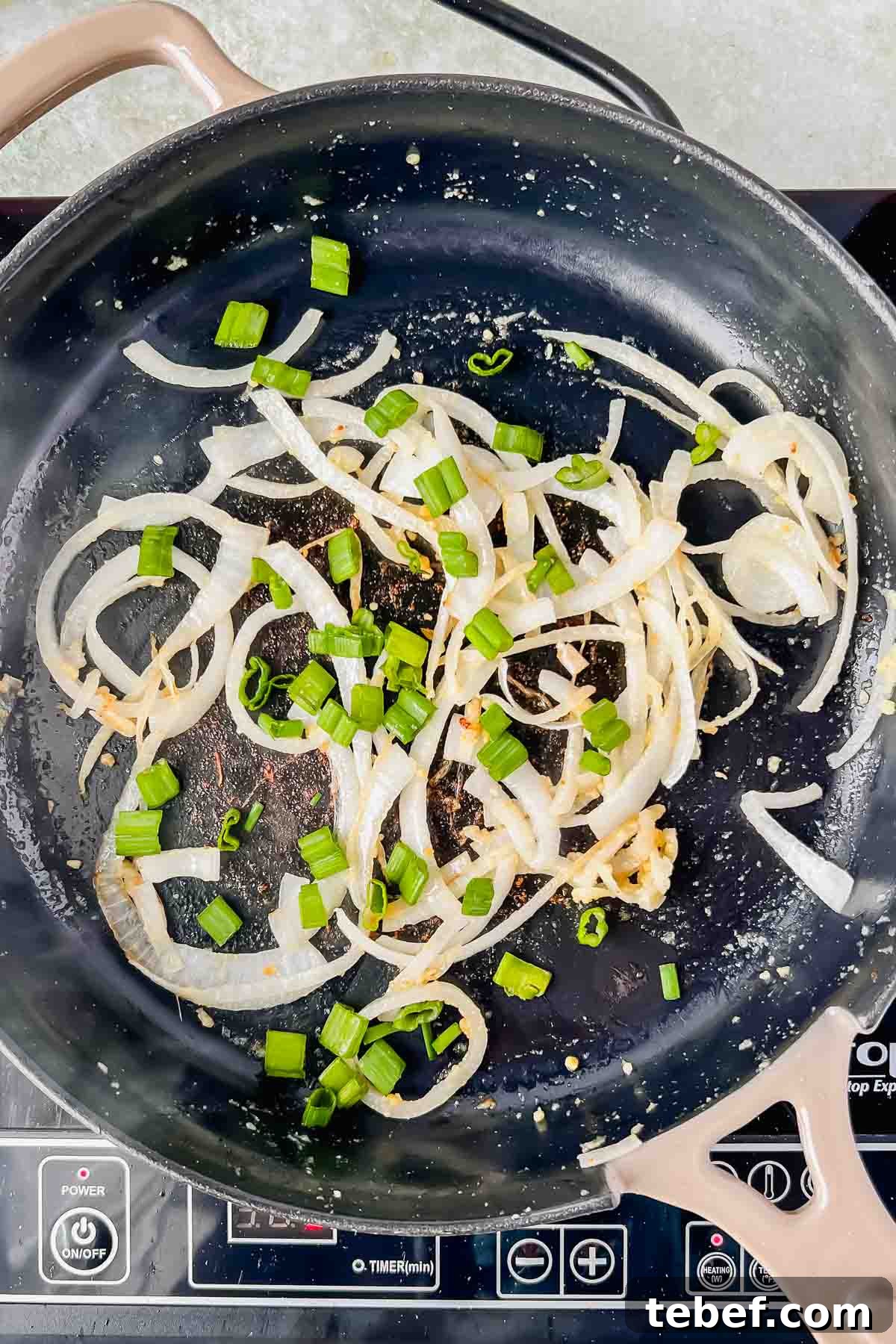 Savory Cheesy Oatmeal Recipe: Comforting Savory Oats in 15 Minutes 5 skillet filled with sautéd white onions, green onions, garlic, and oil.