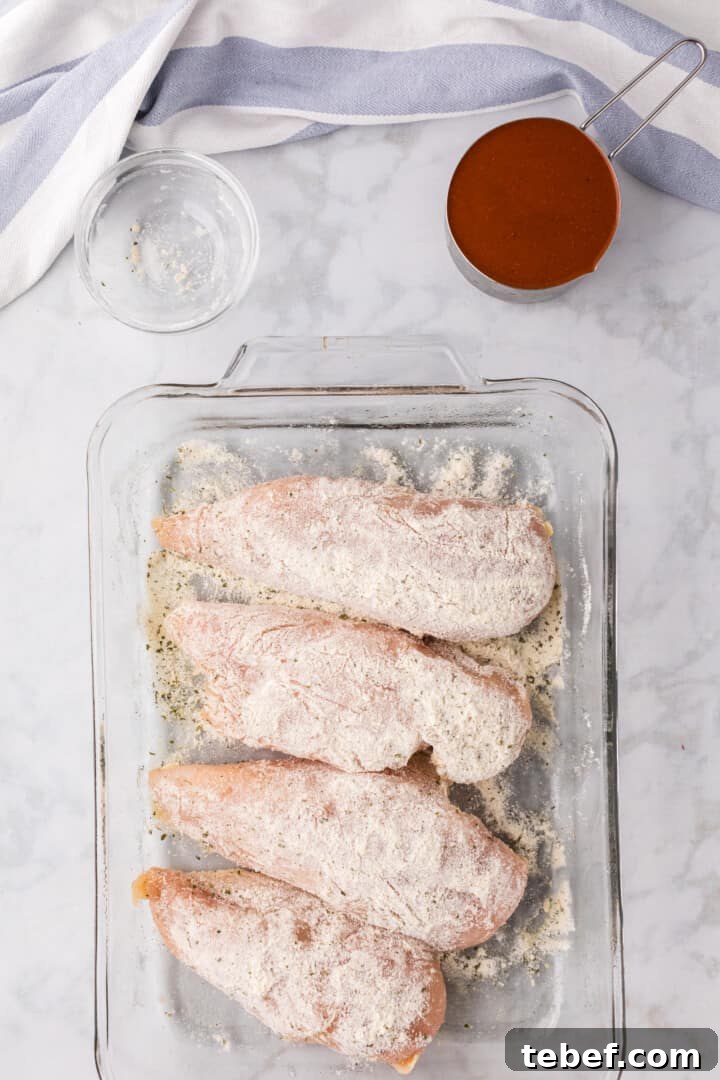 Oven-Baked Buffalo Chicken Thighs with Crispy Skin 4 chicken seasoned with the ranch seasoning in baking dish.