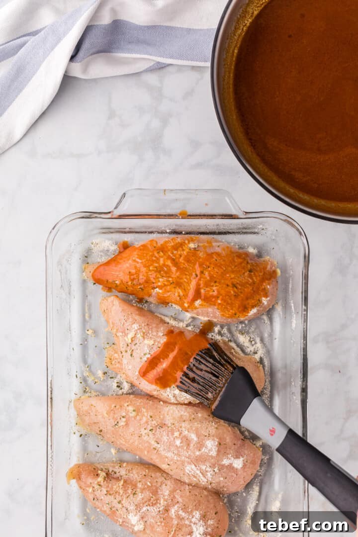 Oven-Baked Buffalo Chicken Thighs with Crispy Skin 6 brushing the chicken with the Buffalo sauce.