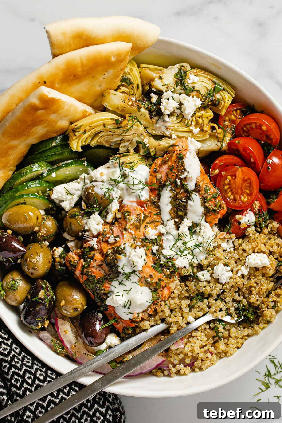 Greek Salmon Bowl Recipe with Lemon-Dill Yogurt Dressing 2 Large white bowl filled with Mediterranean salmon veggies and quinoa