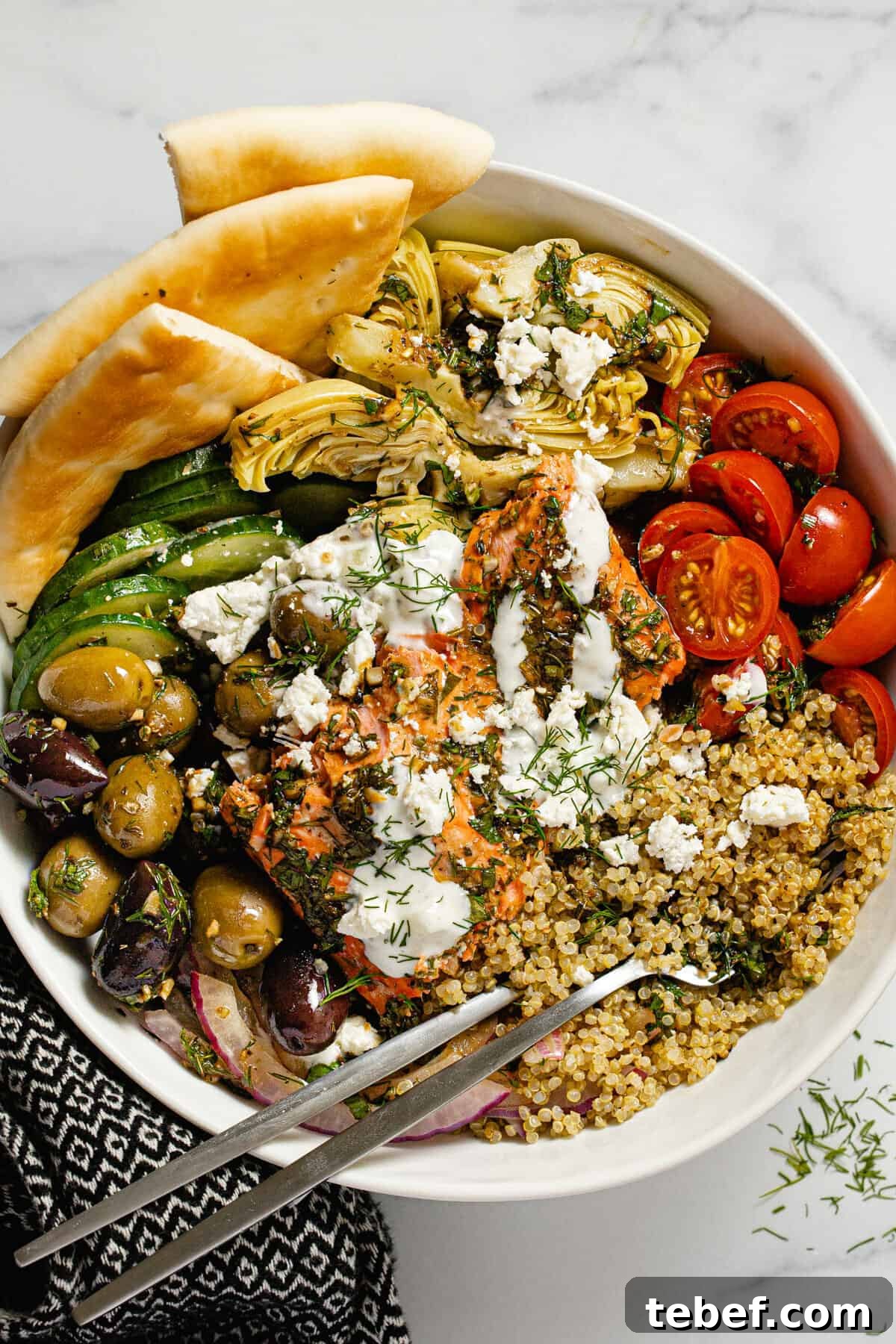 Greek Salmon Bowl Recipe with Lemon-Dill Yogurt Dressing 8 Large white bowl filled with Mediterranean salmon veggies and quinoa