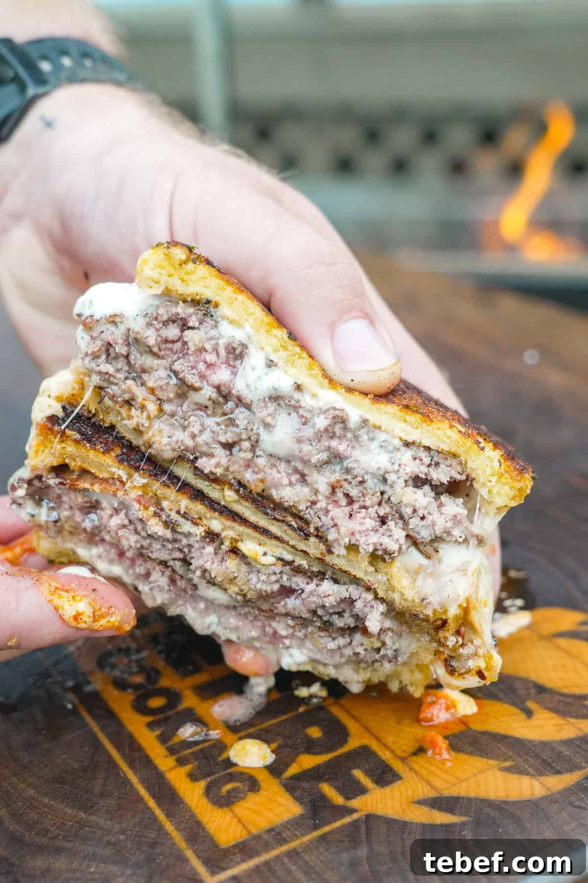 Pizza Smashburger Recipe: Crispy Beef Patty with Melty Pizza Toppings 3 A sliced open pizza smashburger to show the beef patties, mozzarella cheese, pizza sauce and garlic aioli